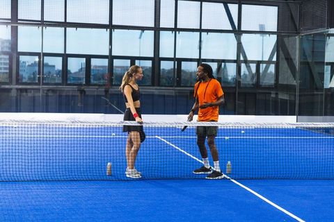 Diverse Tennis Players Conversing on Indoor Court in Sports Hall