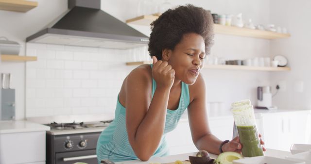 Joyful Woman Enjoying Healthy Green Smoothie in Stylish Kitchen - Download Free Stock Images Pikwizard.com