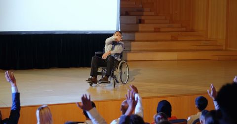 Disabled businessman speaking to engaged audience on stage