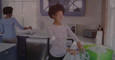 Eco-friendly teen recycling plastic bottles in modern kitchen
