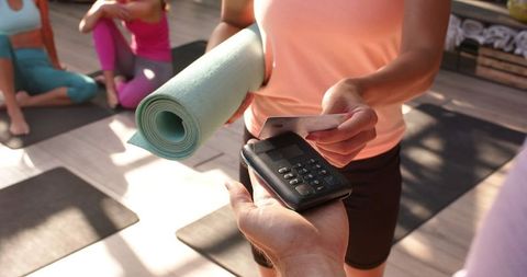 Woman Paying for Yoga Class with Credit Card at Studio