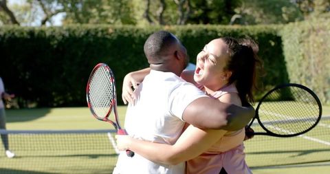 Joyful celebration with diverse friends on tennis court