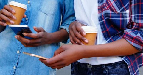 Casual Twin Sisters Drinking Coffee and Using Smartphones Outdoors - Download Free Stock Images Pikwizard.com