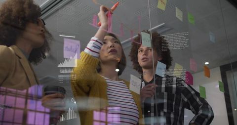 Diverse Business Team Analyzing Financial Data on Transparent Board