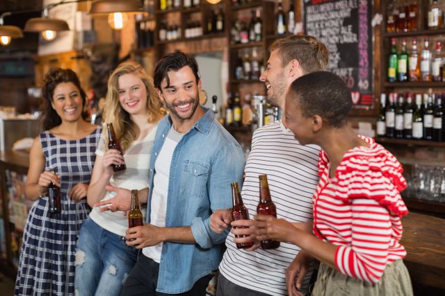 Cheerful friends with beer bottles enjoying at pub