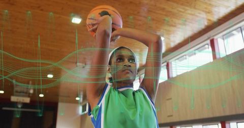 Female basketball player practicing shot in indoor gym