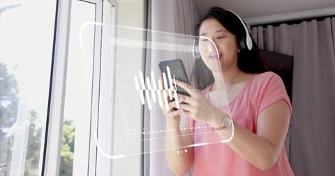 Woman listening with headphones interacting with ar audio waveform on smartphone