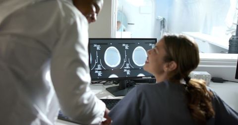 African american doctor and nurse reviewing brain ct scans at radiology workstation