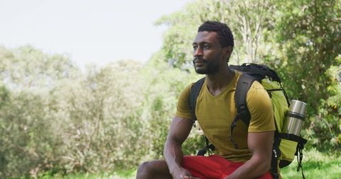 African American Man Resting in Park with Backpack