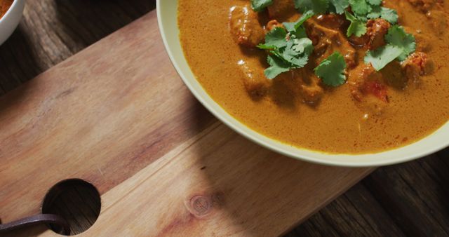 Image of freshly prepared curry in bowl lying on board on wooden surface - Download Free Stock Photos Pikwizard.com