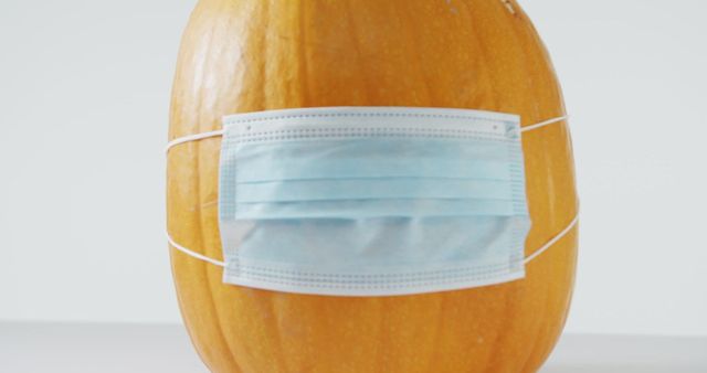 This humorous and creative representation of a pumpkin wearing a face mask highlights the importance of safety and health during the Covid-19 pandemic. Ideal for use in healthcare campaigns, public service announcements, fall and Halloween promotional material, and social media awareness posts. Emphasizes combining tradition with current health directives.