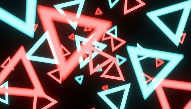 Glowing neon cyan and red triangles swirling through deep black tunnel, motion blur