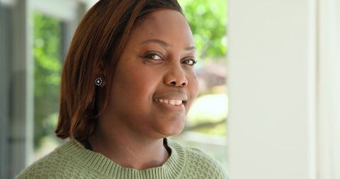 Woman smiling and relaxing at home entrance
