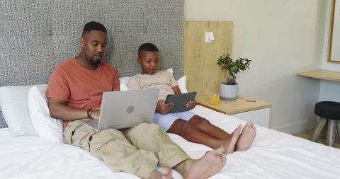 African American Father and Son Spending Quality Time with Devices