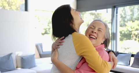 Laughter and Warm Embrace Dark-haired Woman with Older Woman in Living Room