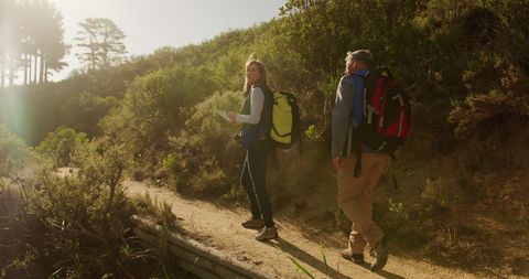 Senior Couple Hiking on Sunny Trail with Backpacks - Download Free Stock Images Pikwizard.com