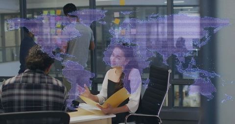 Team collaborating around virtual world map hologram in modern office brainstorming session