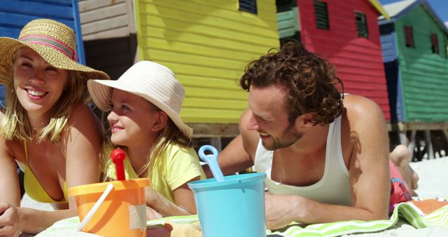 Caucasian Family Bonding on Sunny Beach with Colorful Cabins - Download Free Stock Images Pikwizard.com