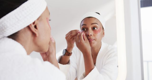 Woman Applying Under-Eye Patches in Bathroom Mirror - Download Free Stock Images Pikwizard.com