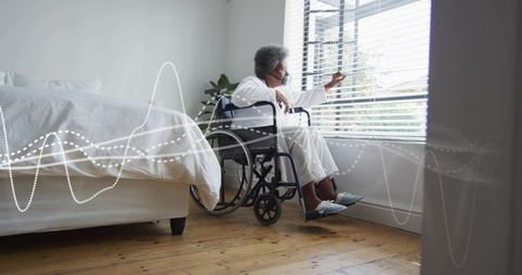 Senior woman in wheelchair adjusting blinds at bedroom window wearing pajamas, soft morning sunlight
