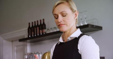 Waitress focused on grating cheese in restaurant setting