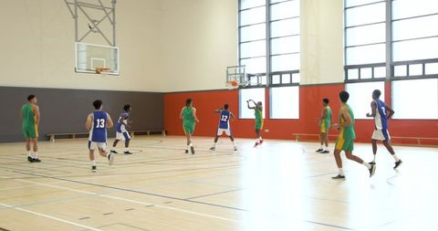 Diverse Basketball Team Practicing Competitive Game Indoors