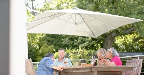 Senior Friends Engaging in Outdoor Leisure Under Large Umbrella - Download Free Stock Images Pikwizard.com