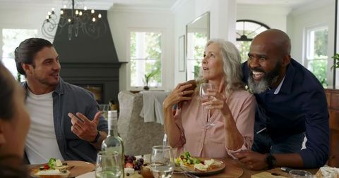 Family Celebration Around Dinner Table, Enjoying Food and Laughter