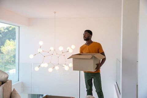 Man Unpacking Box in Modern Spacious Home