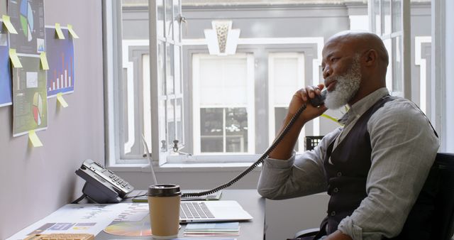 Mature Businessman on Phone While Using Laptop at Office - Download Free Stock Images Pikwizard.com