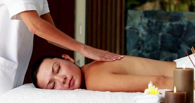 Peaceful brunette enjoying a massage at the spa