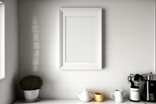 Bright and modern minimalist kitchen with a blank picture frame hanging above a clean countertop. Scene includes potted plant, yellow and white cups, a teapot, and a coffee machine. Ideal for use in home decor articles, kitchen design blogs, or promotional materials for interior design services.