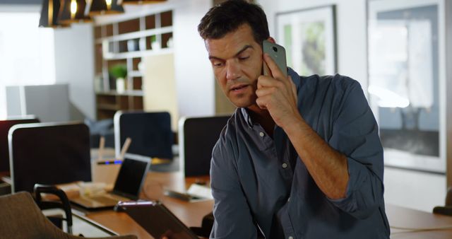 Man multitasking at office with phone and tablet - Download Free Stock Images Pikwizard.com