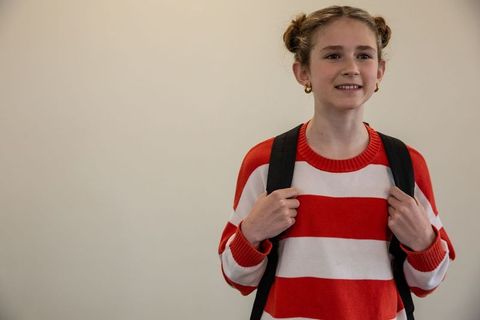 Confident Female Student with Backpack in School Hallway