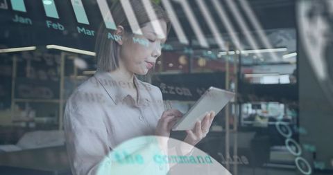 Asian Businesswoman Holding Tablet Tapping Data Dashboard with Glass Interface Overlay