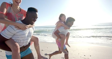 Joyful Couples Enjoy Beach Piggyback Race