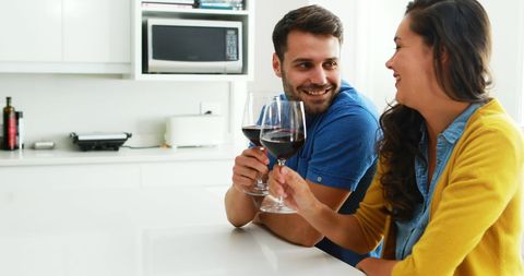 Couple Relaxing in Kitchen with Wine, Sharing a Moment of Joy