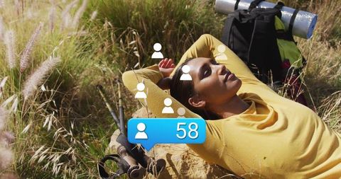 Relaxed hiker resting in scenic meadow with social media concepts