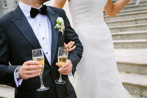 Groom and Bride Toasting Champagne on Stone Staircase After Elegant Wedding Ceremony