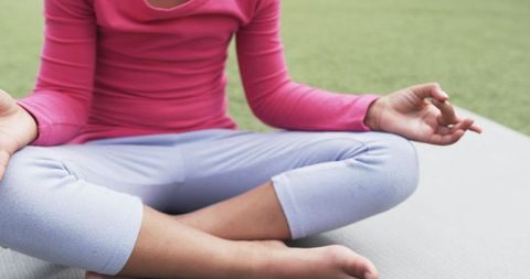Child Practicing Yoga in Meditative Pose on Mat Outdoors