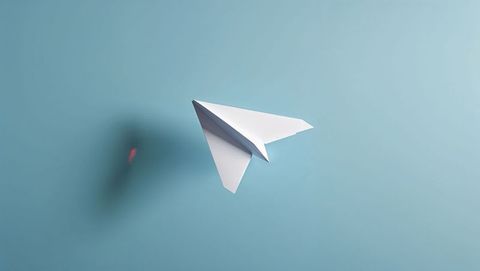 Paper Airplane Soaring in Minimalist Light Blue Space