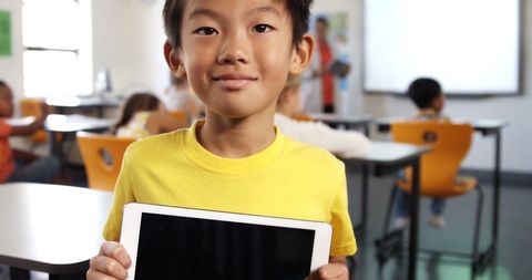 Boy Holding Tablet in Classroom Highlights Digital Learning