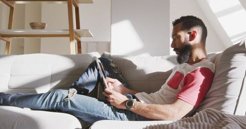 Man Relaxing on Sofa at Weekend Using Tablet - Download Free Stock Images Pikwizard.com