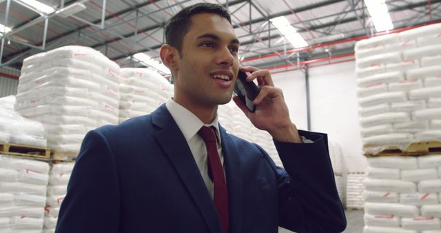 Businessman Speaking on Phone in Warehouse - Download Free Stock Images Pikwizard.com