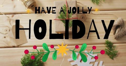 Rustic holiday typography flatlay with kraft gift, holly garland and twine