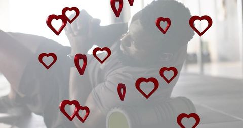 Athlete using foam roller for back mobility and recovery with red heart overlays