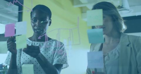Business Colleagues Collaborating With Sticky Notes on Glass Board