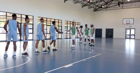 Basketball Players High-Fiving in Indoor Gymnasium