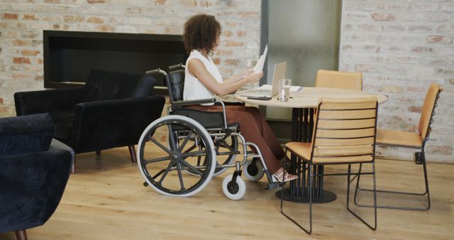 Woman in wheelchair working at modern office desk - Download Free Stock Images Pikwizard.com