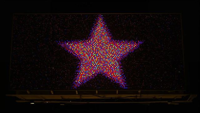 Glowing multicolor led star billboard at night with high-resolution pixel mosaic display
